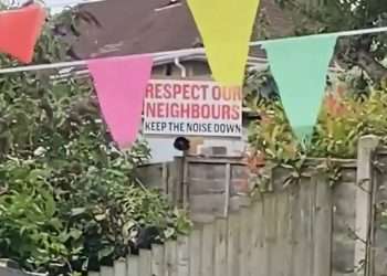Moment nightmare neighbour blasts FOGHORN to drown out school sports’ day after hanging ‘keep the noise down’ sign